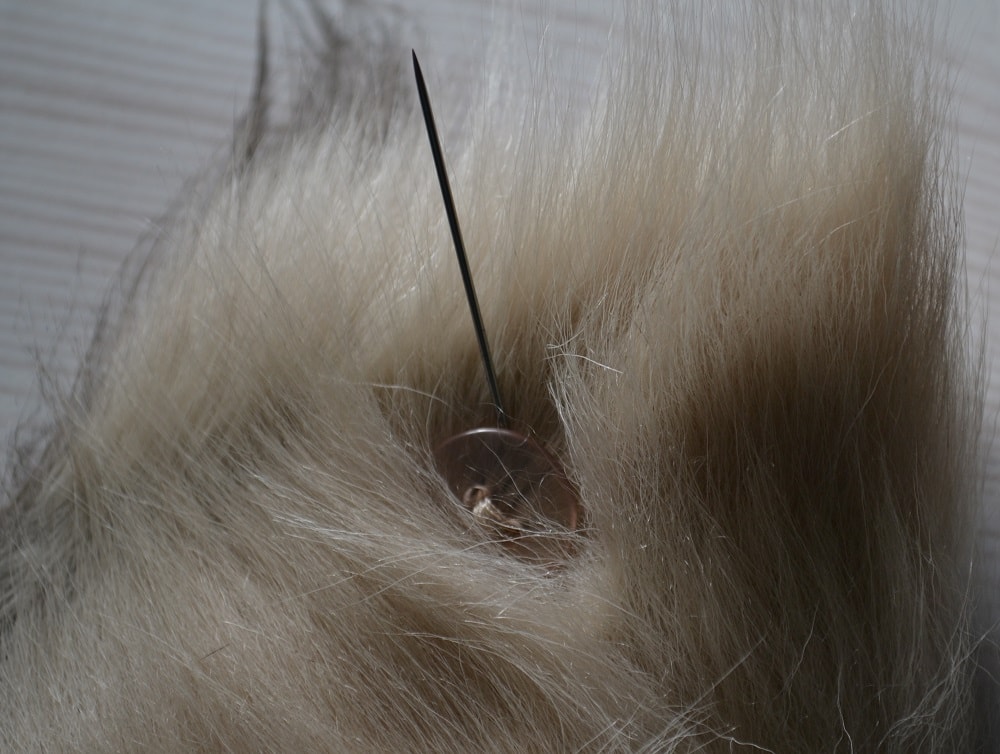 Last steps of sewing a button