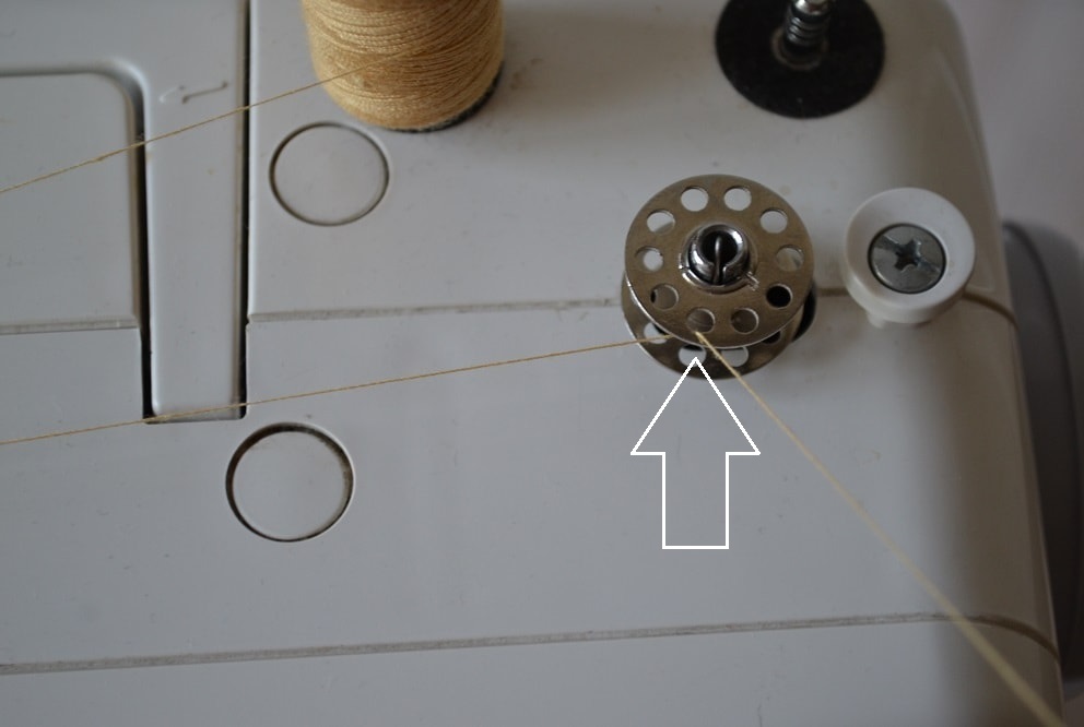 The end of bobbin thread insert through a hole
