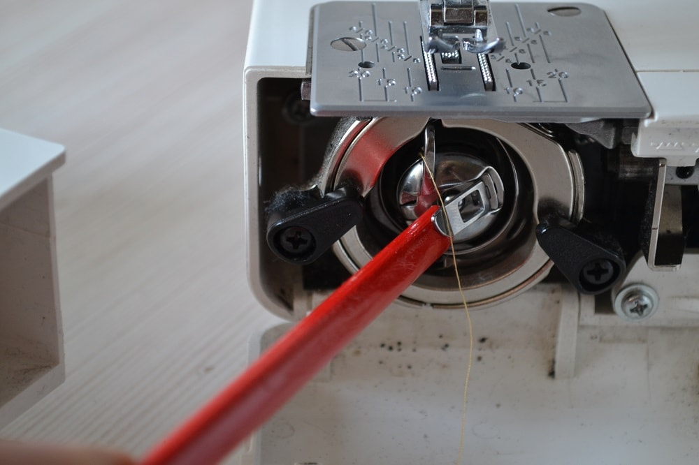 Put bobbin housing back into sewing machine