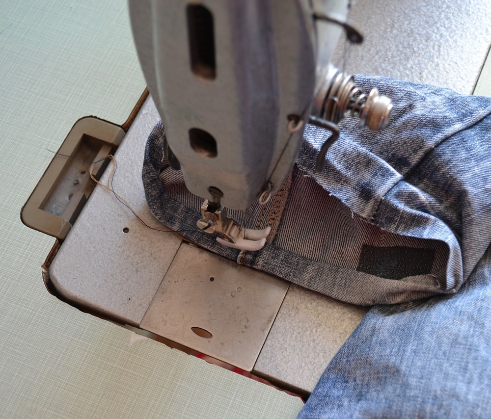 Sewing machine for stitching jeans fabrics