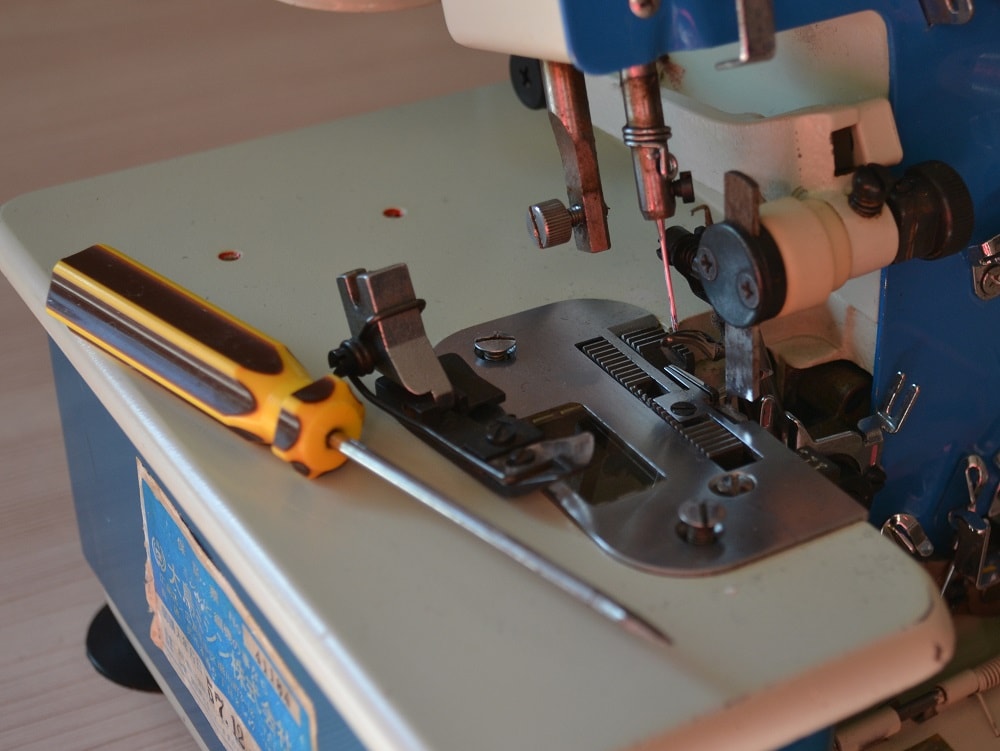 Remove screw holding a presser foot