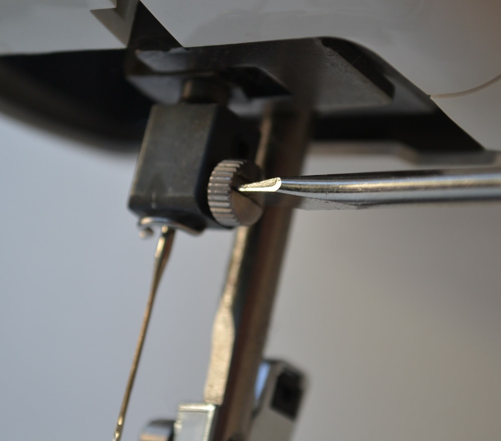 Insert flat screwdriver into the slit of screw