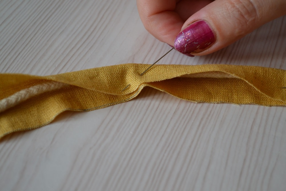 Folded fabric of strip with cord inside