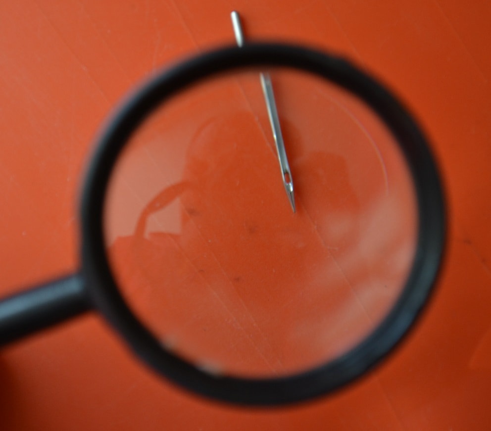 Check needle tip with magnifying glass