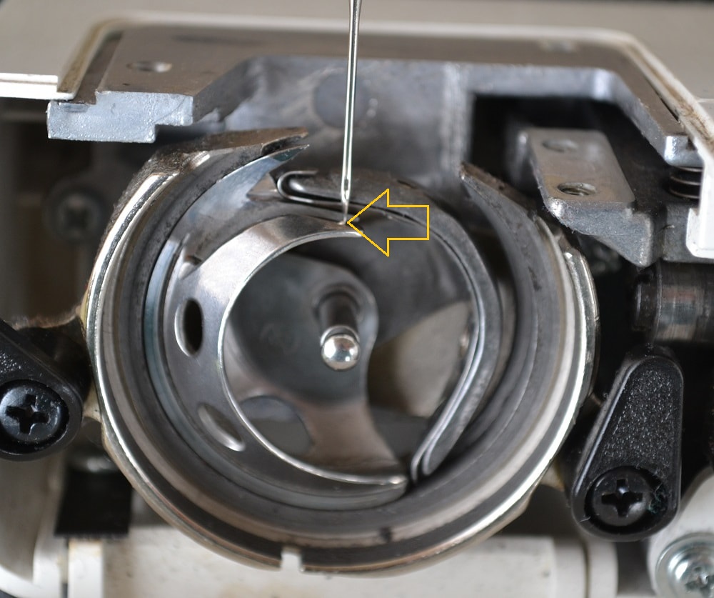 How interacts a sewing needle with a hook tip