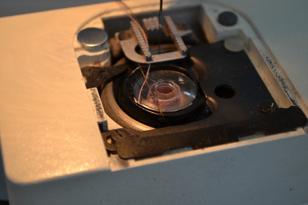 Top thread jumps along plastic shuttle